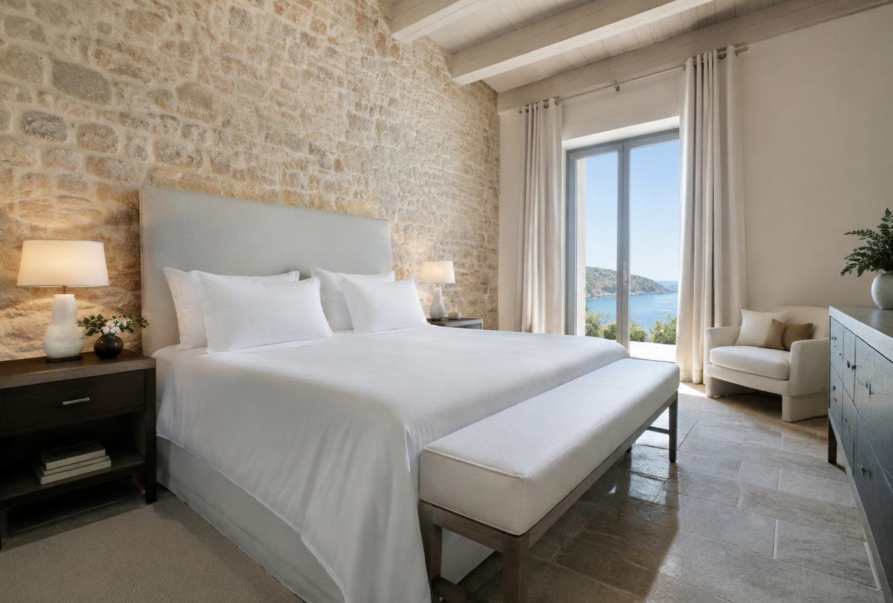 Suite de hotel boutique en Mallorca con cama blanca y banco tapizado